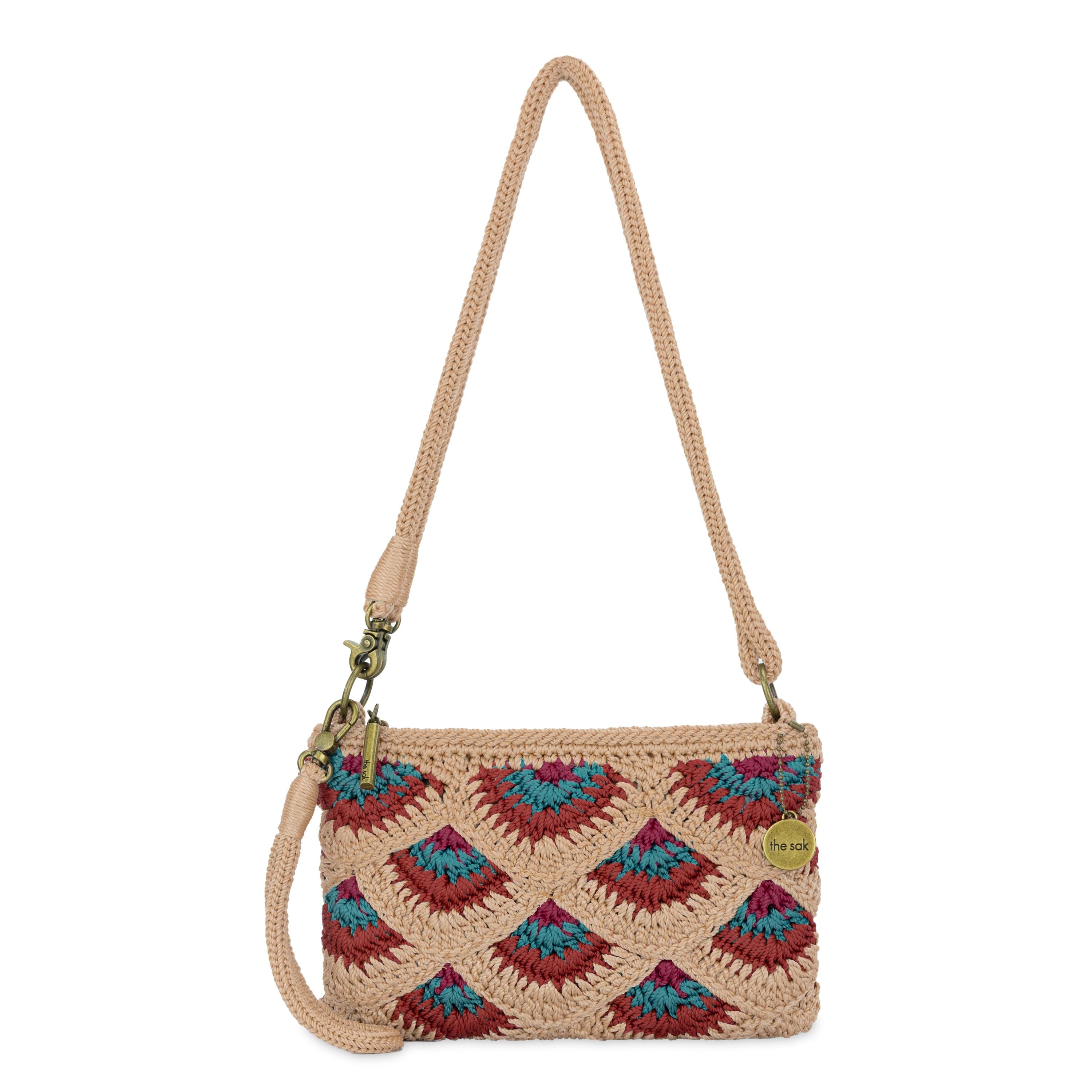 Tan crocheted crossbody bag with red and blue fan pattern, rope handles, and brass hardware.